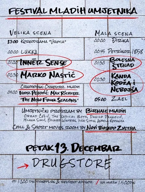 Plakat izdanja u Beogradu: program Velike i Male scene ispisan crnim markerom na sivim kamenim pločama, sa crvenim krugovima